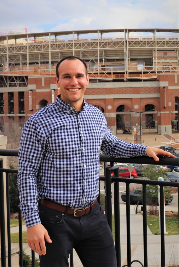 Academic advisor, Chris King stands on pedestrian walkway in front of neyland stadium