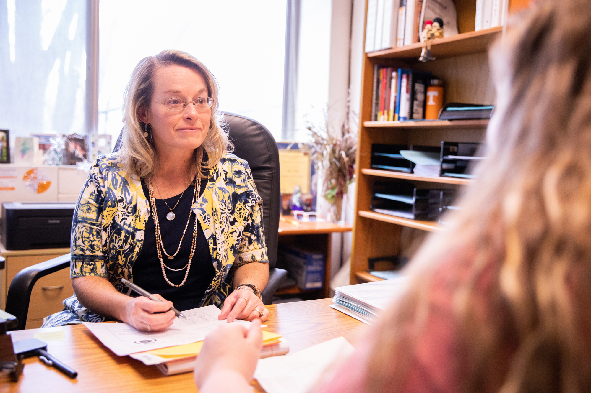 a student and an admissions counselor having a conversation in an office