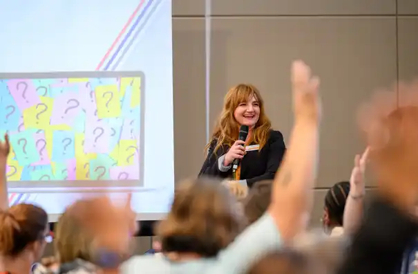 A woman at the head of the conference room talking about Preschool Development