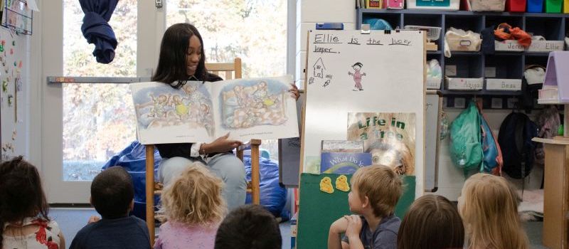 Student intern reading to students in a classroom at Lenoir Elementary