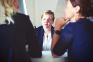 Three women sitting in suits