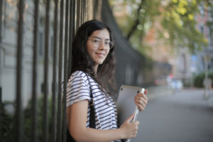 asian Woman in Black and White Striped Shirt Holding Laptop