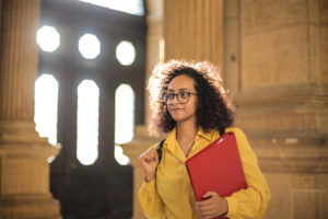 young woman walking in front of architectural building