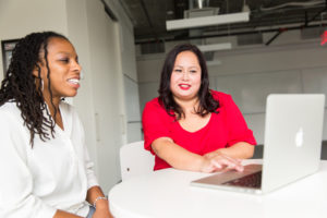 two women working at a laptop