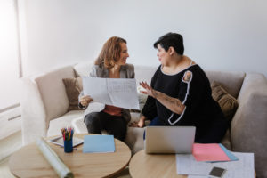 2 women having a discussion about paper