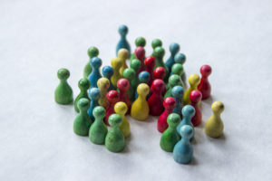 group of multi-colored game pieces symbolizing people in society