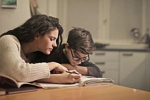 woman working with student on homework