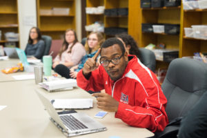 student in classroom using sign language