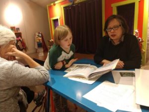 teacher reading with student and parent