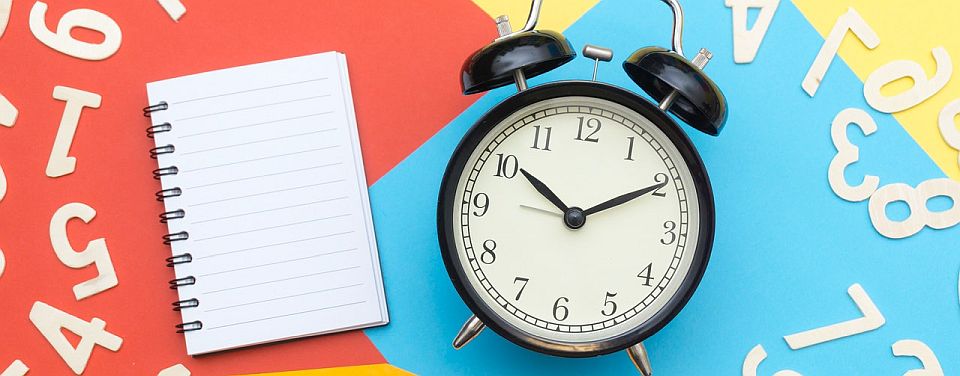 alarm clock, notebook, and numbers and letters all around