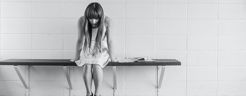 sad girl sitting on a bench
