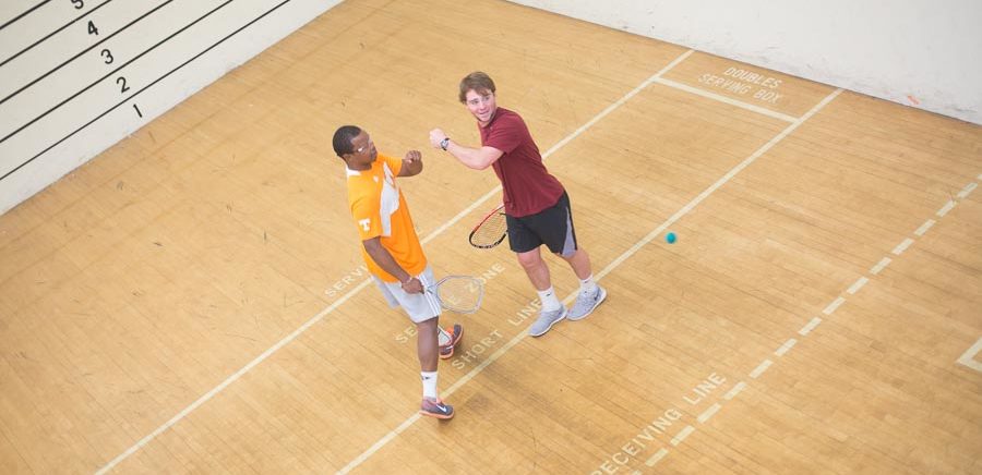Two students playing racquetball in a physical education activity course