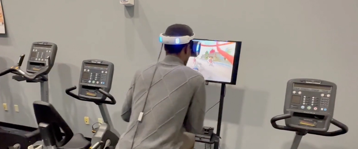 Participant using a virtual reality headset while exercising on fitness equipment