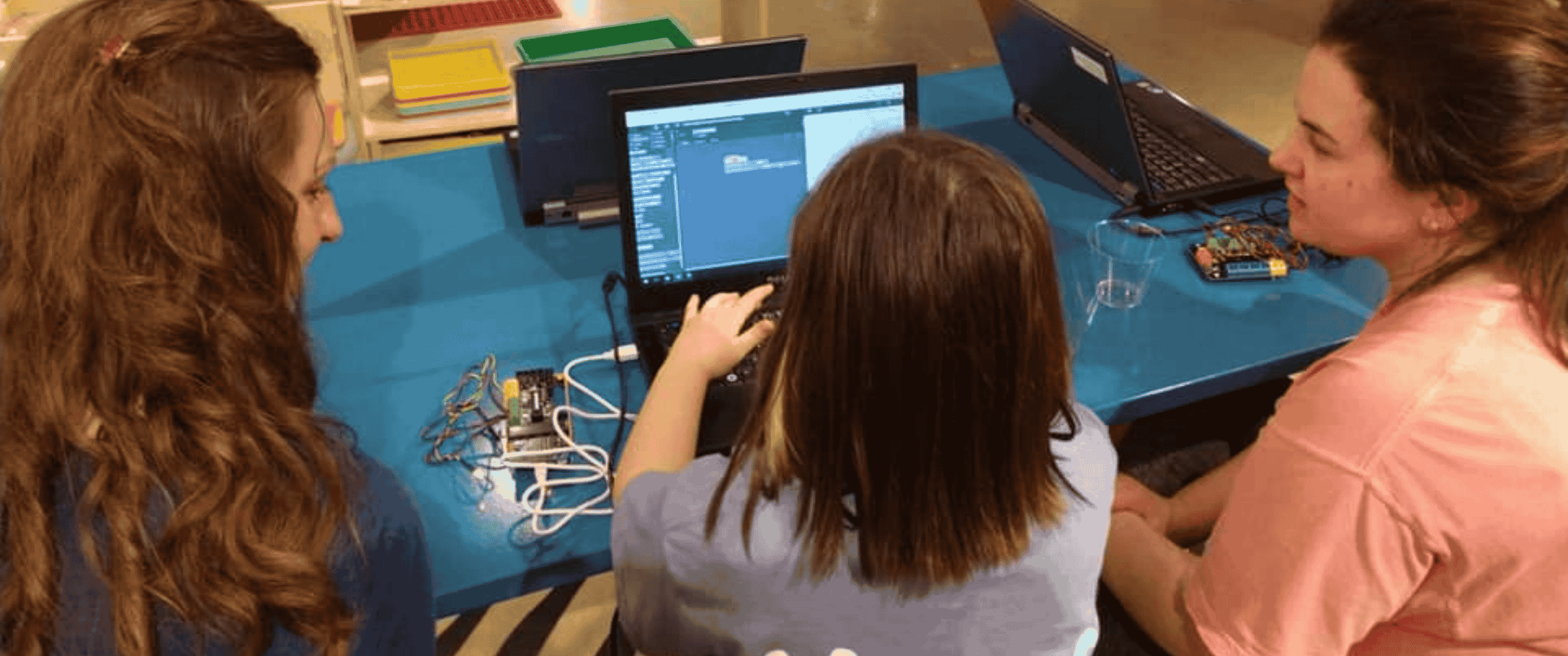 teachers teaching student on laptop