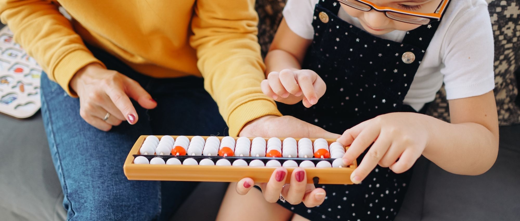 Teacher helping special education student with numbers on abacus
