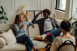 couple sitting on couch having discussion with a counselor