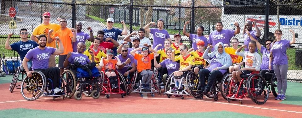 Group of individuals with and without disabilities assembled on a sporting field
