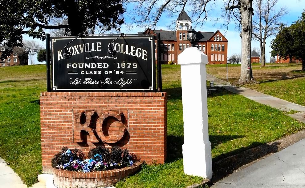 The entrance to Knoxville College with the McKee Hall administration building in the background. The sign at the entrance says "Knoxville College, founded 1875. 'Let There Be Light'"