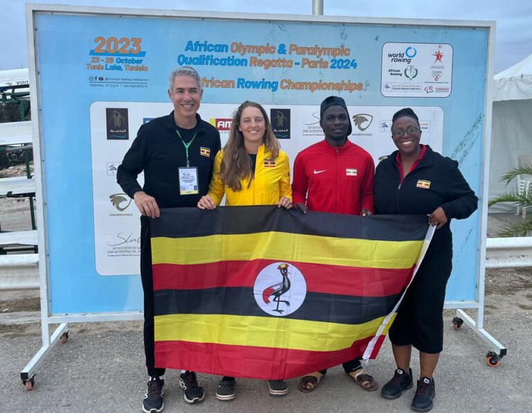 Martinez, Noble, and two other members of the Ugandan Olympic team holding a Ugandan flag