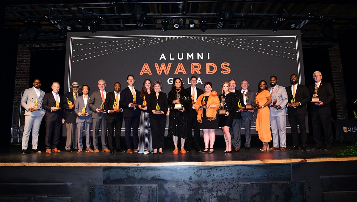 Winners of the 2024 Alumni Awards stand together on a stage