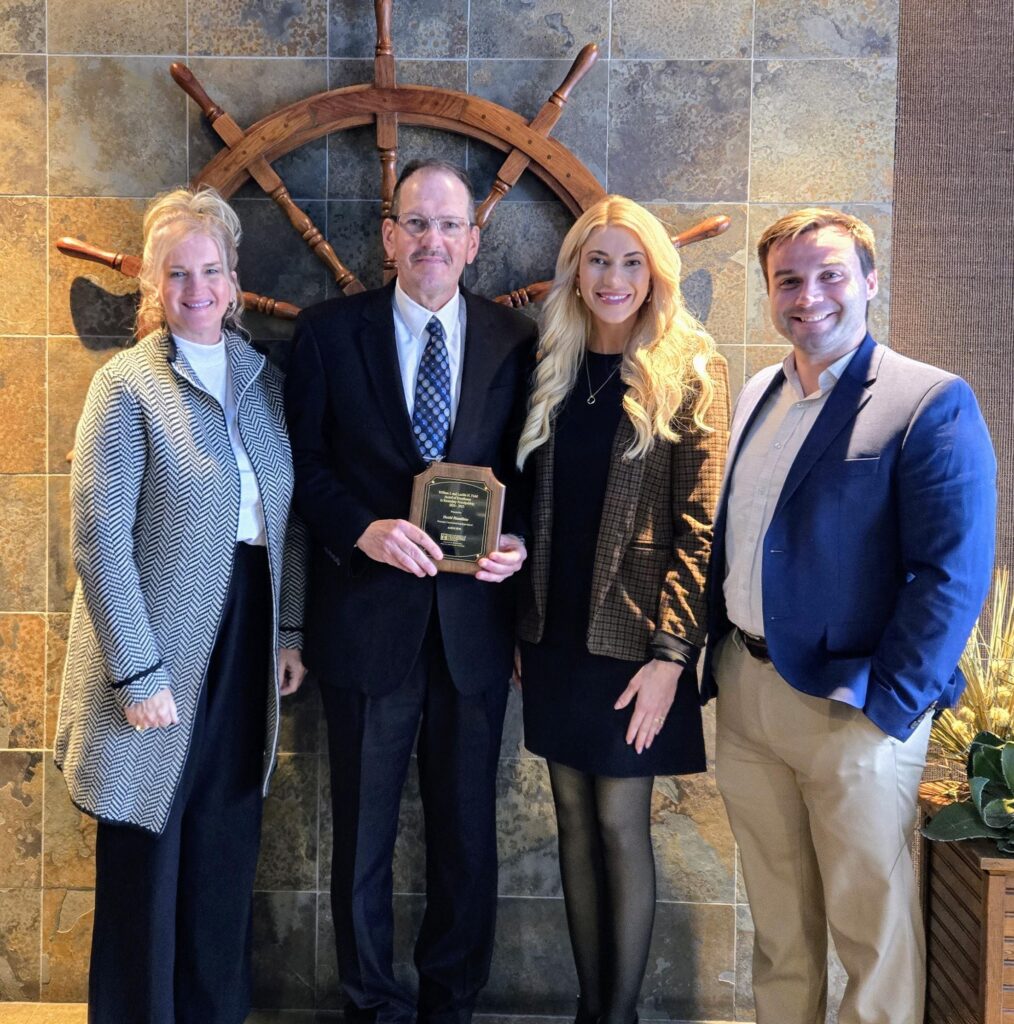 David Hamilton holding his award while taking a photo with his family.